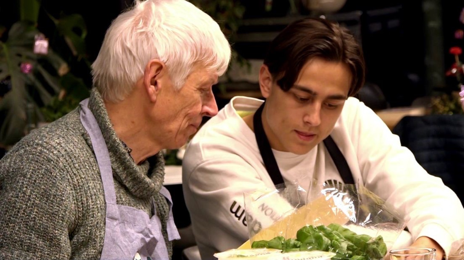 Studenten en mannen koken samen tijdens een kookavond
